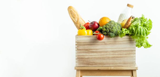 Продуктова дерев'яна коробка зі свіжими фруктами та овочами ізольована на білому тлі. Концепція шопінгу та доставки. Концепція здорового харчування
 - Фото, зображення