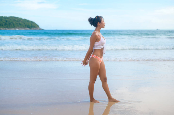 A Young asian woman in bikini doing yoga on the beach, health and meditation concept  - Foto, immagini