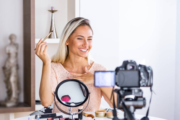 Mooie natuurlijke vrouw professionele schoonheid vlogger of blogger live uitzenden cosmetische make-up tutorial virale videoclip door camera delen op sociale media - Foto, afbeelding