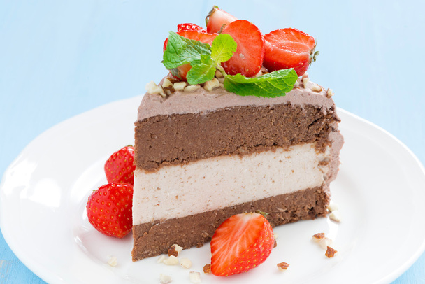 morceau de gâteau au chocolat de trois couches avec des fraises fraîches
  - Photo, image