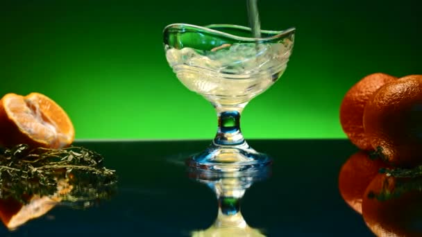 Ποτό με πορτοκάλια και έντονο φως στο παρασκήνιο χύνεται σε γυαλί. Κλιπ μετοχών. Μπαρ ατμόσφαιρα και αλκοολούχο ποτό με φρούτα. Ανθρακούχο ποτό με φρούτα γύρω χύνεται σε διαφανές ποτό.  - Πλάνα, βίντεο