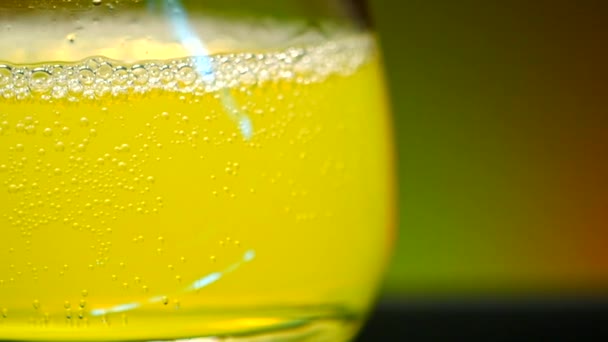 Close-up of glass with yellow drink. Stock clip. Alcoholic drink with gases in glass on background of bar. Alcoholic drink in nightclub.  - Footage, Video