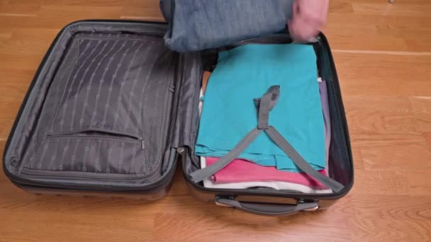 Close-up zicht op de man die kleding inpakt in bagage voor het reizen. Zweden. - Video