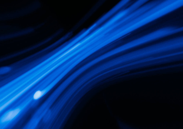 Blur laser glow. Futuristic light flare. Sci-Fi radiance. Defocused ultraviolet neon navy blue color curve lines reflection motion on dark black trendy abstract background. - Foto, imagen