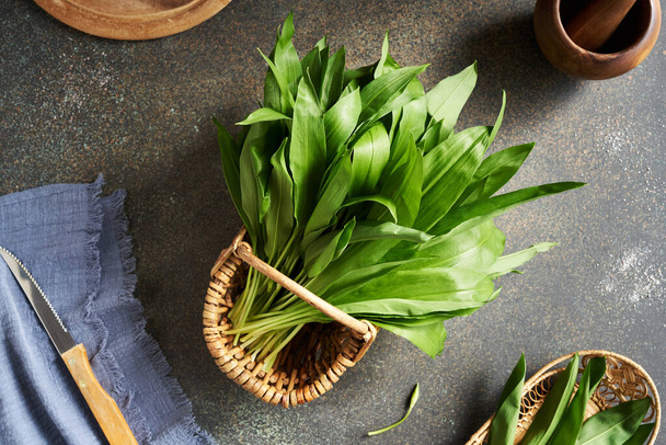 Fresh young wild garlic leaves on a table, top view - Foto, immagini