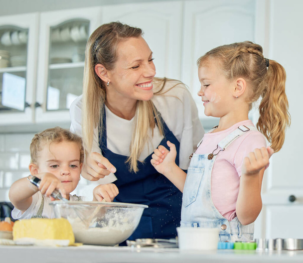 Ευτυχισμένη αγαπημένη οικογένεια ψήνεται μαζί. Μητέρα και δύο κόρες μαγειρεύουν μπισκότα και διασκεδάζουν στην κουζίνα. Σπιτικό φαγητό και μικρός βοηθός - Φωτογραφία, εικόνα