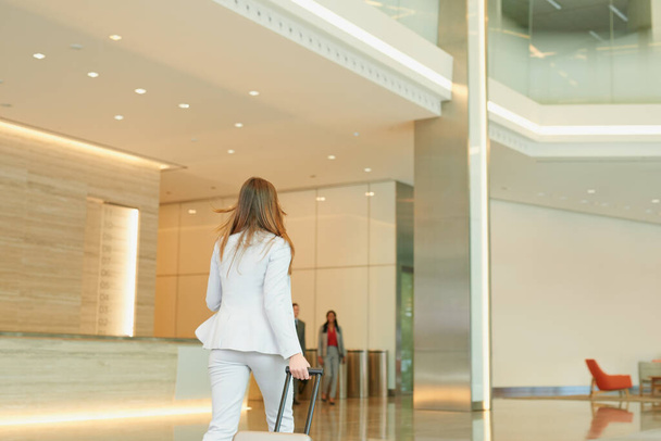 Business woman walking through an airport terminal for business travel. - Photo, image