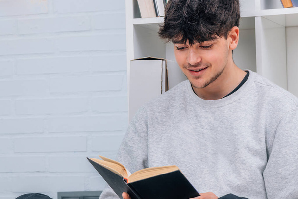 μαθητής ή νεαρός άνδρας που διαβάζει ένα βιβλίο στο σπίτι - Φωτογραφία, εικόνα