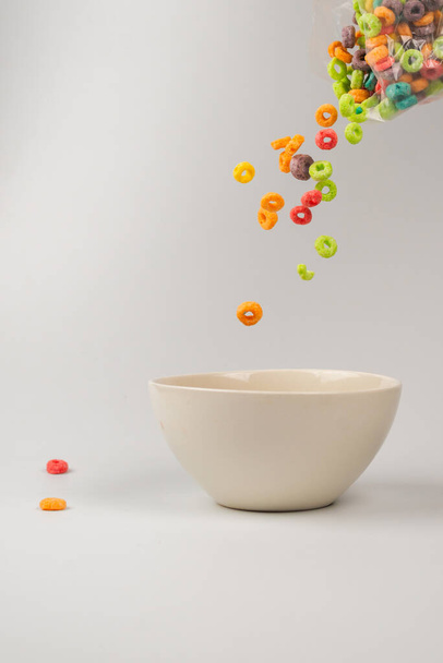 Colorful cereal box for morning breakfast. Corn flakes falling to the white bowl. Motion. Copyspace. - Foto, immagini