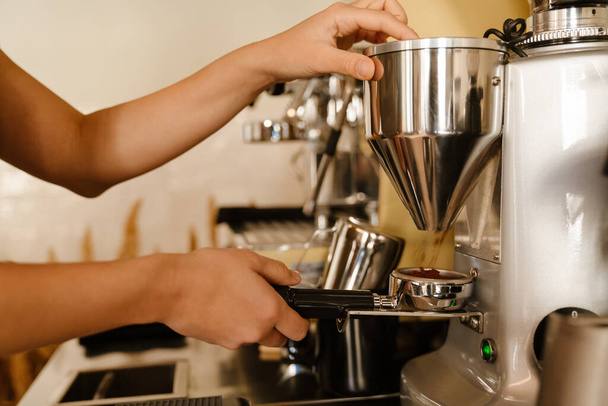 Young barista making coffee while working in cafe - Foto, imagen