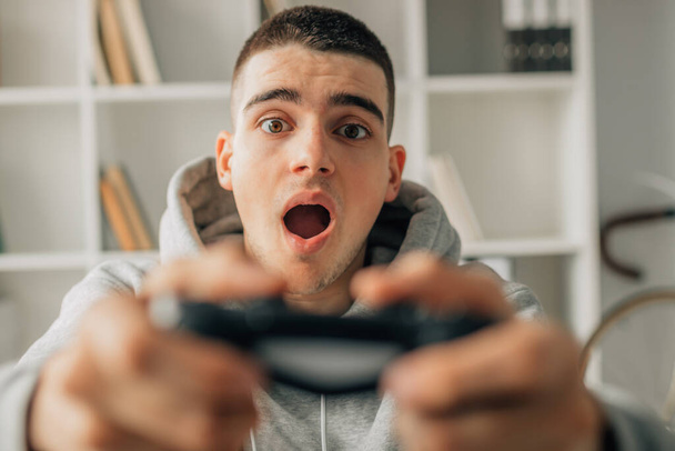 Genç adam video oyunu denetleyicisiyle oynuyor - Fotoğraf, Görsel
