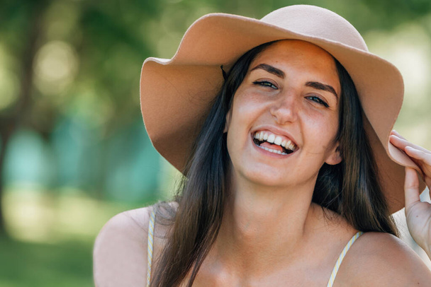 Porträt eines Mädchens mit Hut, das im Sommer im Freien lächelt - Foto, Bild
