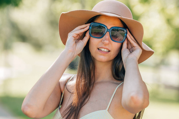 retrato de niña en verano con sombrero y gafas de sol en la calle - Foto, Imagen