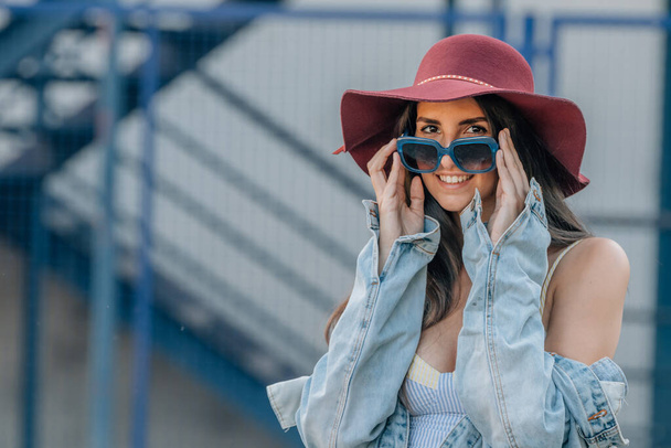 αστικό στυλ hipster κορίτσι με γυαλιά ηλίου και καπέλο στο δρόμο - Φωτογραφία, εικόνα
