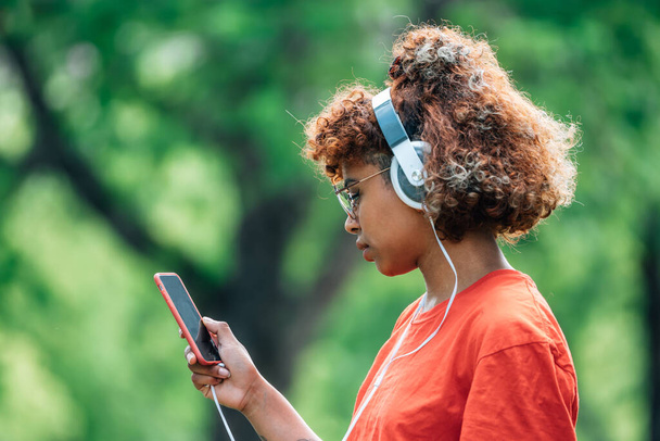 african american girl with mobile phone and headphones - Fotoğraf, Görsel
