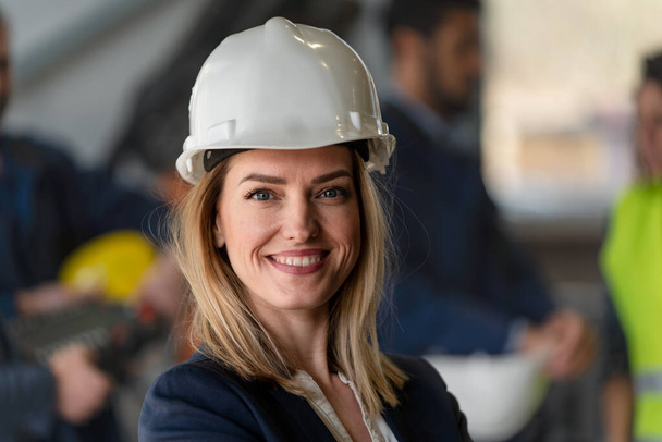 A portrait of female chief engineer in modern industrial factory looking at camera. - Foto, Bild