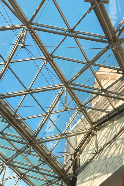 Geometrische Metallstruktur mit Glas, Decke in einem Einkaufszentrum gegen den Himmel - Foto, Bild