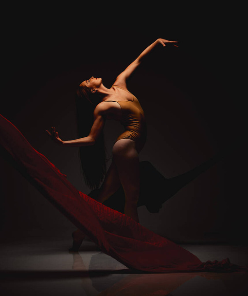 Снимок исполнителя, танцующего на тёмном фоне. - Фото, изображение