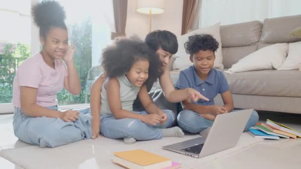 家庭のリビングルームで学び、勉強するためにオンラインでビデオメディアを見てラップトップコンピュータを使用して母親と子供と幸せアフリカの家族,お母さんが子供を教える,教育の概念. - 映像、動画