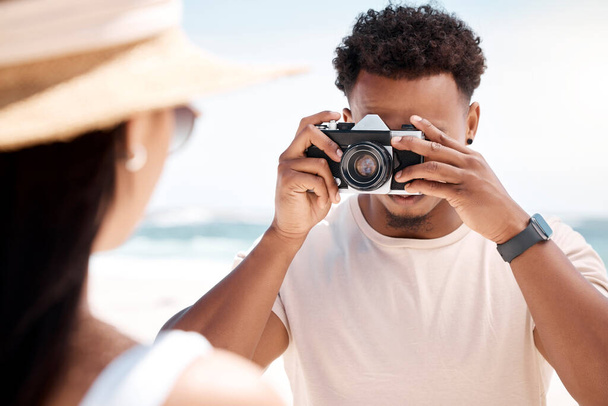 Shot of a young man taking a picture of his girlfriend at the beach. - Photo, Image