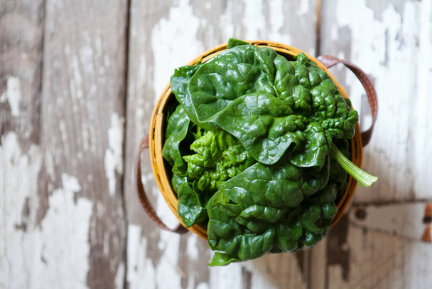 Large Fresh Spinach Leaves in a Basket on Barn Wood - Foto, Bild