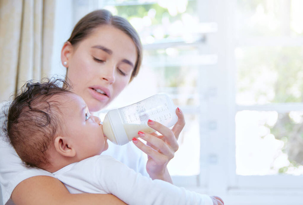 Tourné d'une jeune femme qui donne du lait à son bébé. - Photo, image