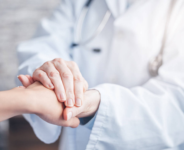 Closeup shot of an unrecognisable doctor holding a patients hand in comfort. - Foto, imagen