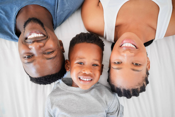 High angle shot of a happy family relaxing on a bed together at home. - Fotó, kép
