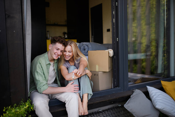 A cheerful young couple in their new apartment. Conception of moving. - Foto, afbeelding