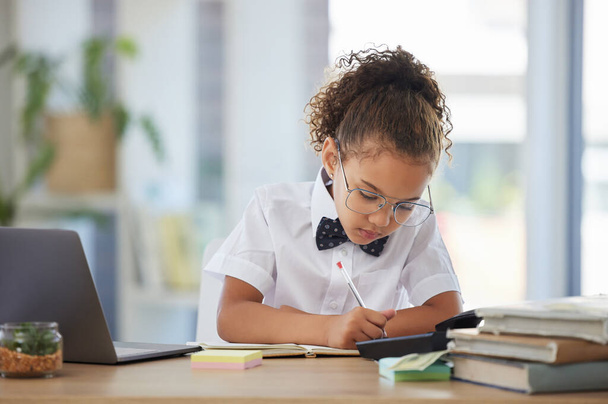 Знімок чарівної маленької дівчинки, одягненої як бізнесмен, сидить наодинці в офісі і пише нотатки
. - Фото, зображення
