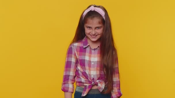 Lovely cheerful young preteen child girl kid greatly approves your suggestion, shaking head Yes approvely, satisfied with good quality work, like proposal. Little toddler children on yellow background - Záběry, video