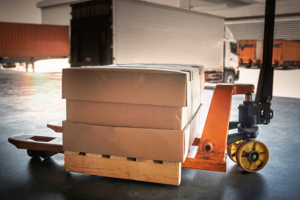 Packaging Boxes on Wooden Pallet with Hand Pallet Jack. Cargo Shipment. Supplies Warehouse. Shipping Trucks Logistics. - Photo, Image