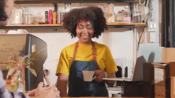 Africké americké ženské kavárny barista v příležitostné zástěře spokojeni s online objednávkou zákazníka v notebooku, veselá práce s úsměvem na pultu baru v kavárně, malý business start-up podnikatel životní styl. - Záběry, video