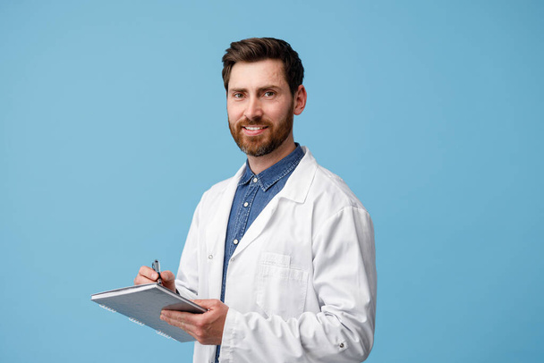  Muotokuva ammatillinen mies lääkäri valkoinen yhtenäinen tilalla lääketieteellinen kaavio sininen tausta - Valokuva, kuva