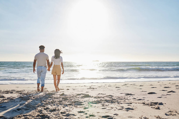 Largura completa de una pareja joven y cariñosa dando un paseo por la playa. - Foto, imagen
