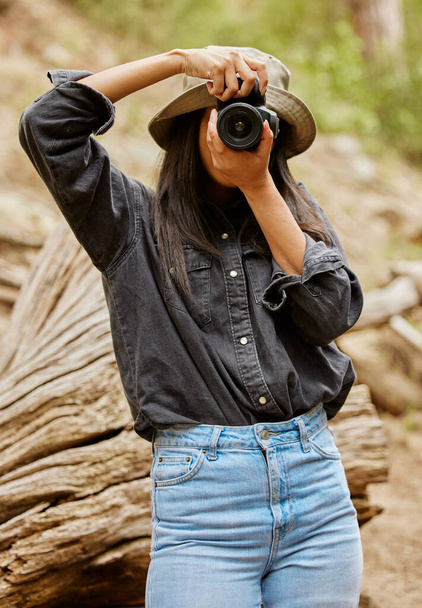 Cropped shot of an attractive young woman taking photographs while hiking in the wilderness. - Foto, Imagen