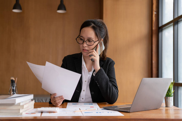 Busy business accountant woman making call phone in office and business working background, tax, accounting, statistics and analytic research concept. - Foto, imagen