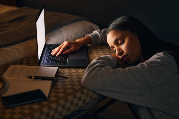Recorte de una atractiva joven que duerme mientras estudia hasta tarde en la noche en su dormitorio en casa. - Foto, Imagen