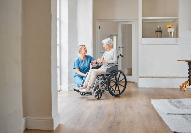 Strzał pielęgniarki opiekującej się starszą kobietą na wózku inwalidzkim w domu spokojnej starości. - Zdjęcie, obraz