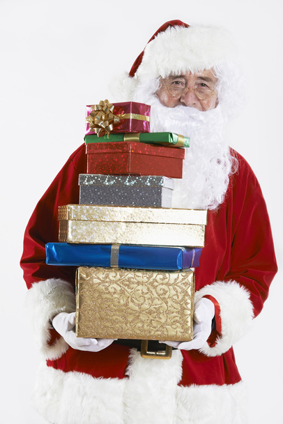 Άγιος Βασίλης, κρατώντας την σωρό του δώρου τυλιγμένα δώρα - Φωτογραφία, εικόνα