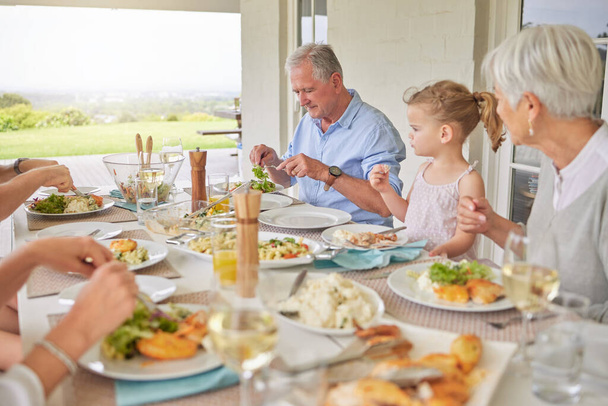 Tourné d'une famille profitant du déjeuner du dimanche ensemble sur leur terrasse. - Photo, image
