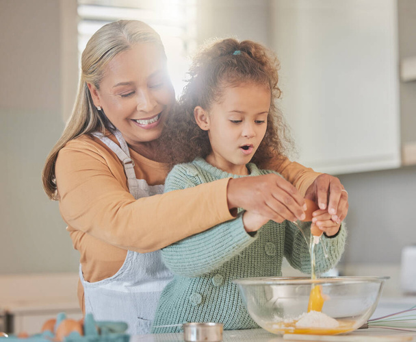 Shot of a woman baking with her granddaughter at home. - Foto, imagen