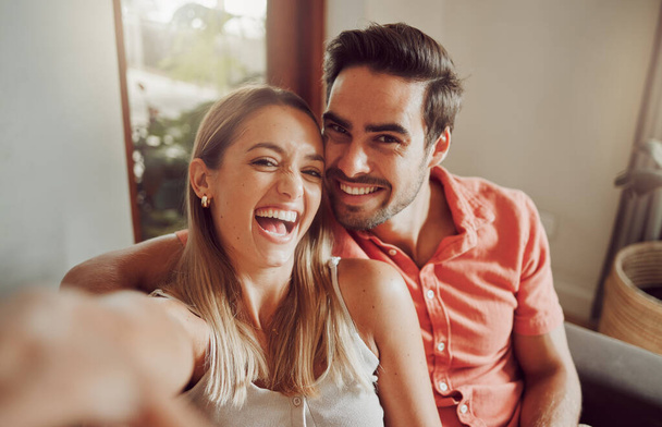 Prise de vue d'un jeune couple prenant un selfie ensemble à la maison. - Photo, image