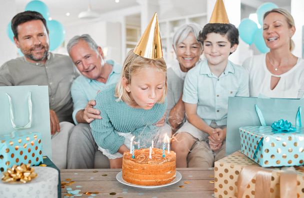 Μια φωτογραφία μιας ευτυχισμένης οικογένειας να γιορτάζει τα γενέθλιά της μαζί στο σπίτι.. - Φωτογραφία, εικόνα