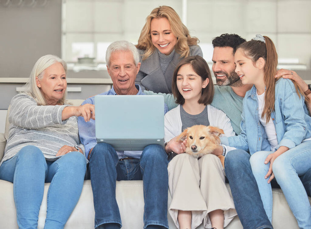 Съемка семьи с помощью ноутбука, сидящей вместе на диване дома. - Фото, изображение