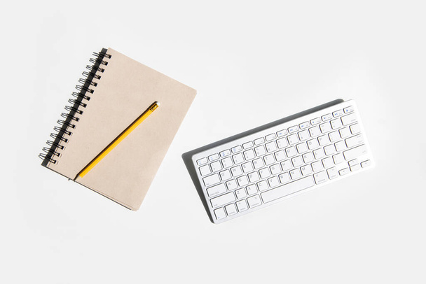 Keyboard, blank notepad on white background. Top view, flat lay. - Foto, Bild