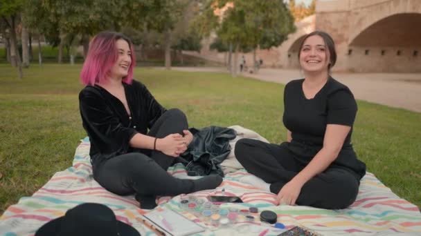 boldog fiatal fehér lányok szórakozás és pihenés a nyilvános parkban. slomo - Vízszintes 4K videó - Felvétel, videó
