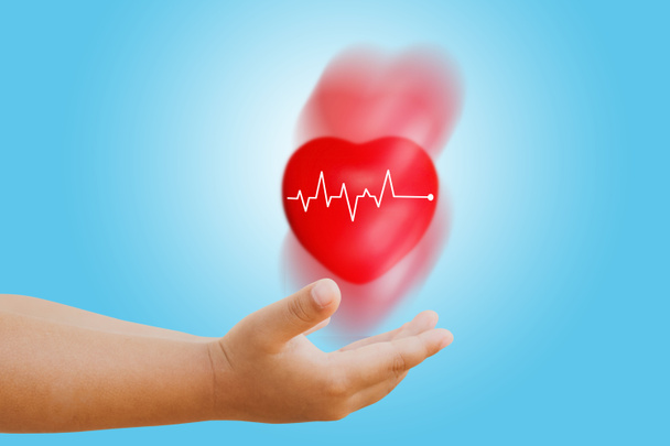 Cute boy 's ręka rzucanie piłki serca z pulsu medycznego i czerwony ruch serca: Opieka zdrowotna i profilaktyka koncepcji ostrego ataku serca. - Zdjęcie, obraz