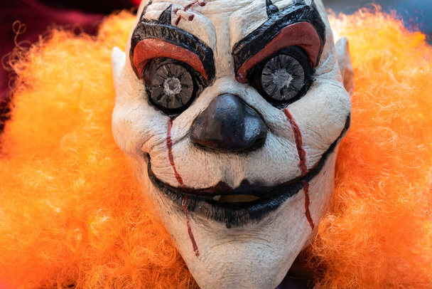 Portrait of bad bloody clown with orange hair. Horror Clown. Blood freak. horror movie clown. Halloween celebration party - Fotó, kép