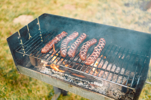 Grilling sausages with the addition of herbs on barbecue grill. Selective focus.  - Foto, Imagem